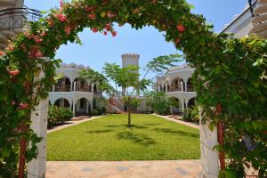 an archway in front of a building with flowers at Diani Pearl in Diani Beach