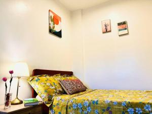 um quarto com uma cama e uma mesa com um candeeiro em Iloilo Affordable Transient - near Iloilo Airport 