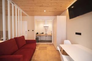 sala de estar con sofá rojo y cocina en APARTAMENTOS CASA ARADIÑA en Ríotorto