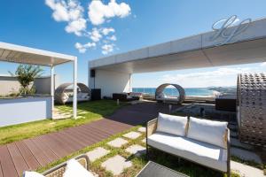 a patio with furniture and a view of the ocean at SL Hotel Gangneung in Gangneung