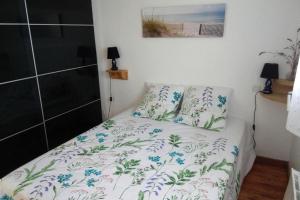 una piccola camera da letto con un letto con copriletto floreale di Holiday Home Pleubian - BRE02104c-F a Pleubian