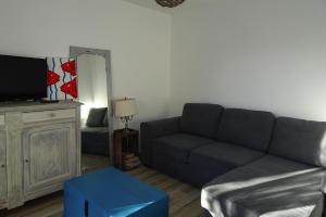 un soggiorno con divano e TV di Holiday Home Pleubian - BRE02104c-F a Pleubian