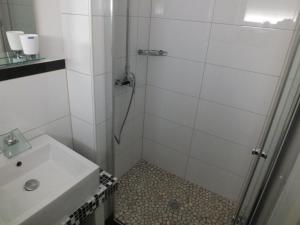 ein Bad mit einer Dusche und einem Waschbecken in der Unterkunft Pension Apartment Burscheid in Burscheid
