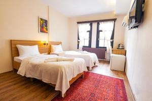 a bedroom with two beds and a red rug at Simre Inn Hotel Safranbolu in Safranbolu