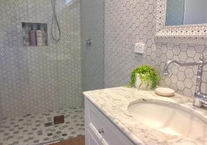 La salle de bains est pourvue d'un lavabo blanc et d'une douche. dans l'établissement Hamptons In Rye Studio - 3 Mins from Famous Hot Springs!, à Rye