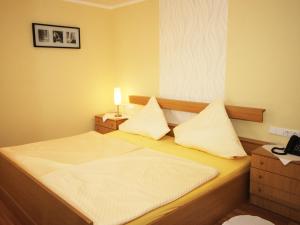 ein kleines Schlafzimmer mit einem Bett mit weißer Bettwäsche in der Unterkunft Landhotel Weinrich in Naumburg