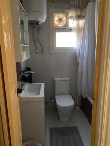 Baño pequeño con aseo y lavamanos en Cozy warm 2BR Apartment in a world class compound, en Madinaty