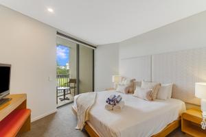 Un dormitorio con una cama con dos zapatos. en Deluxe Dual-Key Apartment in Peppers @ Salt Resort by uHoliday (3BR, 2BR and Hotel Room Options Available) en Kingscliff