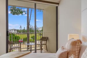 1 dormitorio con cama y vistas a un balcón en Deluxe Dual-Key Apartment in Peppers @ Salt Resort by uHoliday (3BR, 2BR and Hotel Room Options Available) en Kingscliff