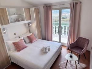 a bedroom with a bed with pink pillows and a window at Apartments with parking space Lopar, Rab - 14070 in Lopar