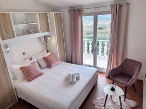 a bedroom with a bed with pink pillows and a window at Apartments with a parking space Lopar, Rab - 14070 in Lopar