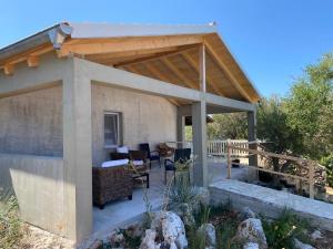 a pavilion with a table and chairs on a patio at Secluded fisherman's cottage Krknata, Dugi otok - 399 in Žman