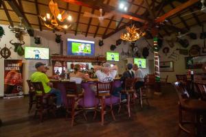 a group of people sitting at a bar in a restaurant at Hotel La Calzada in Granada