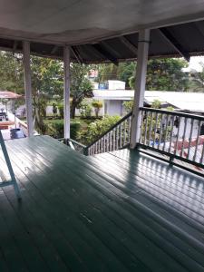 a wooden deck with a table and a chair on it at Adorable 2-bedroom stay with Balcony in Almirante