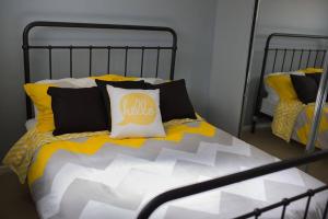 a bed with yellow and black pillows on it at Nelson Bay home on the beach!! in Nelson Bay