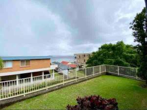a large yard with a white fence and grass at Nelson Bay home on the beach!! in Nelson Bay