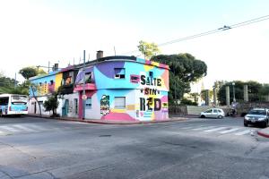 un edificio colorido al lado de una calle en Hostel Joven casa Reggae en Córdoba