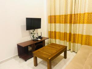 ein Wohnzimmer mit einem Tisch und einem TV darauf in der Unterkunft Splendour Residencies Colombo in Colombo