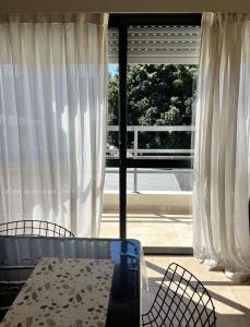 a room with a table and chairs and a large window at 9 de Julio Apart in Concepción del Uruguay