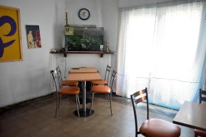 une table et des chaises dans une pièce avec une horloge murale dans l'établissement Hostel Joven casa Reggae, à Córdoba