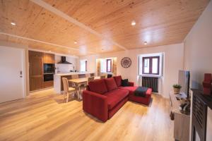 a living room with a red couch and a table at APARTAMENTOS CASA ARADIÑA 2 in Ríotorto