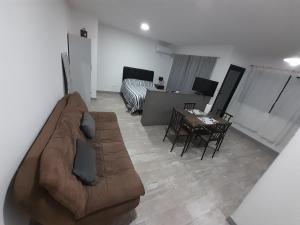 sala de estar con sofá marrón y mesa en París 2 Monoambiente en Rosario