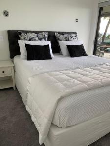 a large white bed in a bedroom with a window at Sea Veiws Kaha Place in Russell