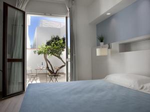 a bedroom with a bed and a view of a patio at Hotel Perla Gaia in San Vito lo Capo