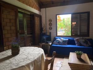 un soggiorno con un divano blu e una finestra di Casa a 100 mts da praia! a Garopaba Altre 11 foto