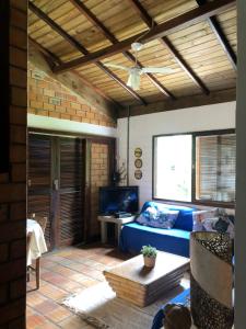 un soggiorno con un divano blu e una TV di Casa a 100 mts da praia! a Garopaba