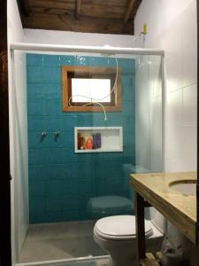 bagno con servizi igienici e parete piastrellata blu di Casa a 100 mts da praia! a Garopaba