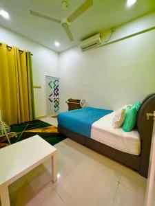 Auranad Guest House Tanah Merah Wifi-Netflix في Kampong Tanah Merah: غرفة نوم فيها سرير وطاولة فيها