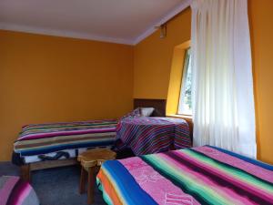two beds in a room with yellow walls at Musiña Lodge in Ocosuyo