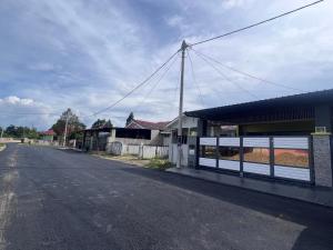 Auranad Guest House Tanah Merah Wifi-Netflix في Kampong Tanah Merah: شارع فاضي بجانب عماره فيها سياج
