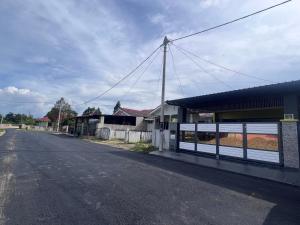 an empty street next to a building with a fence at Auranad Guest House Tanah Merah Wifi-Netflix in Kampong Tanah Merah