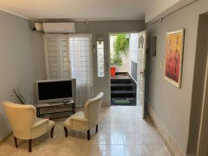 een woonkamer met 2 stoelen en een televisie bij CERRO CHICO APART in Cordoba