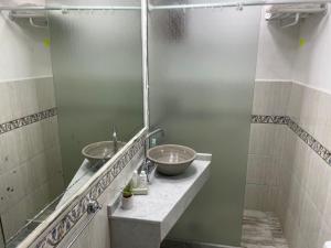 een badkamer met 2 wastafels en een spiegel bij CERRO CHICO APART in Cordoba