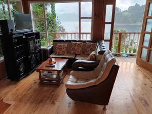 sala de estar con sofá y mesa en Cabaña de descanso arcoiris del lago 3, en Pasto