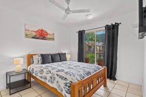 a bedroom with a bed and a window at The Lazy Breeze in Cannonvale