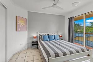 a bedroom with a large bed and a window at The Lazy Breeze in Cannonvale