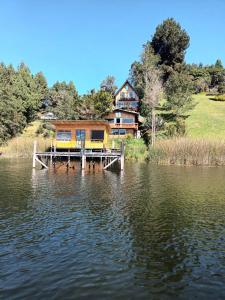 une maison sur un quai au-dessus d'une masse d'eau dans l'établissement Cabañas de descanso, arcoiris del lago 1, à El Encano
