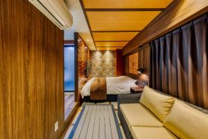 een slaapkamer met een bed en een bank in een kamer bij Hotel Lotus Okayama Adult Only -Adult Only in Okayama