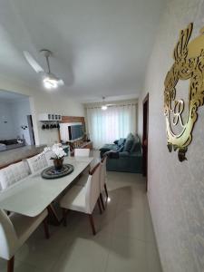 - une salle à manger et un salon avec une table et des chaises dans l'établissement Casa Azul - Linda casa Familiar com Piscina no Peró em Cabo Frio, à Cabo Frio