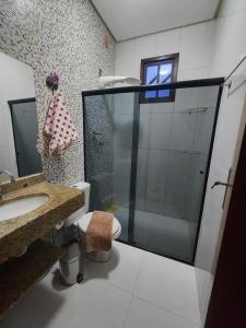 a bathroom with a shower and a toilet and a sink at Casa da Cíntia in Lençóis