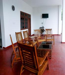 Pokój z drewnianymi krzesłami, stołem i telewizorem w obiekcie Sashen Hotel w mieście Ella