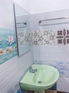 een badkamer met een wastafel en een spiegel bij Sashen Hotel in Ella