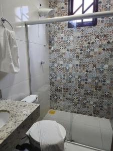 a bathroom with a shower and a toilet and a sink at Casa da Cíntia in Lençóis