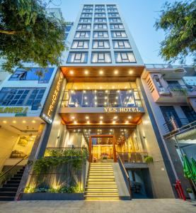 ダナンにあるYes Hotel Đà Nẵngのv mas hotelの入り口へ続く階段のある建物