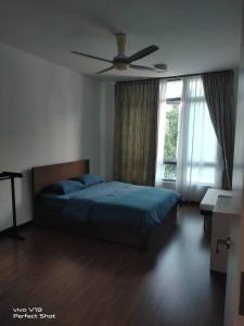 een slaapkamer met een bed en een plafondventilator bij Summer Glades, Cyberjaya in Cyberjaya