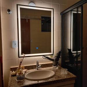 a bathroom with a sink and a mirror at Encantos do Porto da Barra in Salvador